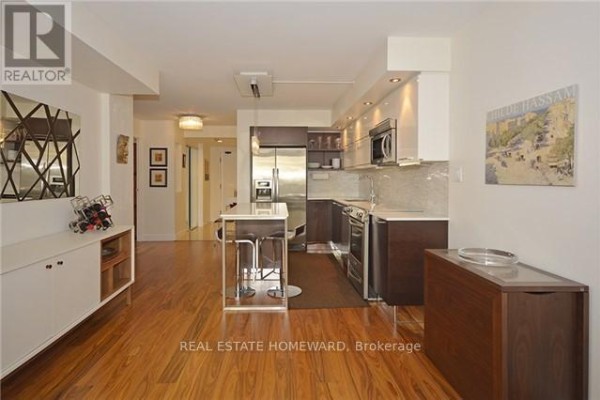 Combined kitchen and living area with island, hardwood floors, and contemporary furnishings. - 1912 - 15 Maitland Place, Toronto