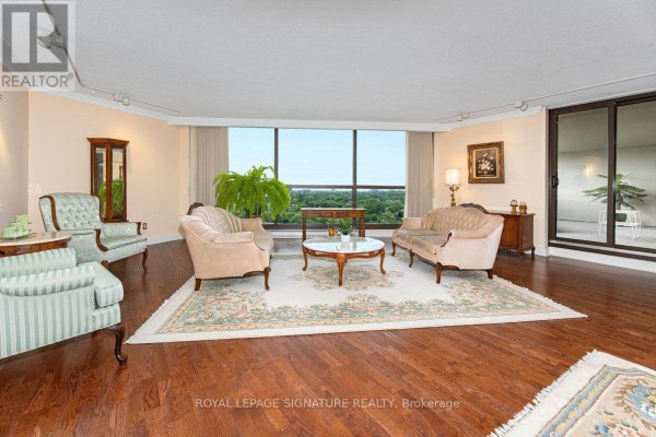 A living room with plush furniture, hardwood floors, large windows, and a view. - 1912 - 2000 Islington Avenue, Toronto