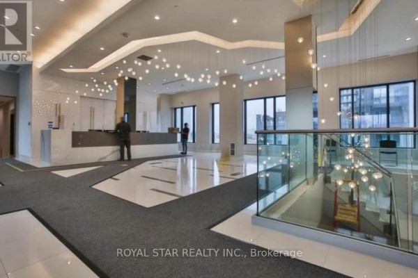 Spacious, modern condo lobby with marble floors, contemporary lighting, and a reception desk. - 1913 - 35 Watergarden Drive, Mississauga