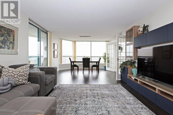 View of the living and dining area with panoramic windows and a modern entertainment unit. - 1913 - 4725 Sheppard Avenue E, Toronto