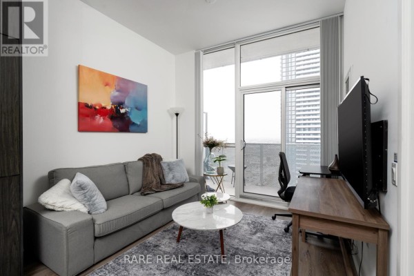Living room featuring a gray sofa, artwork, and access to a balcony - 1916 - 28 Interchange Way, Vaughan