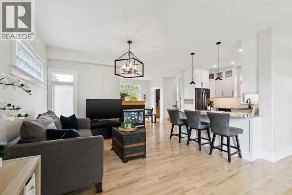 Spacious living room featuring a grand piano, seating, and natural light. - 1917 27 Avenue Sw, Calgary
