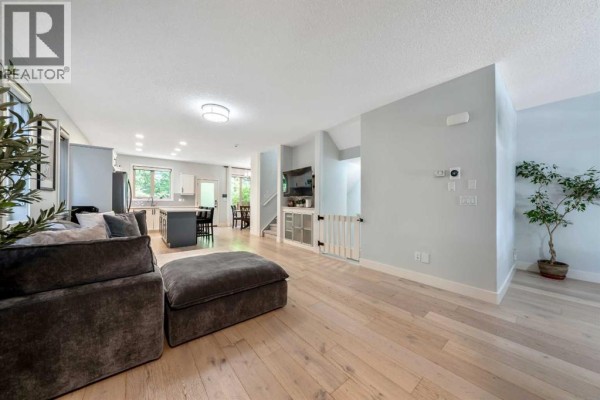 Backyard with wooden fence, gravel patio, trees and a small bench. - 1918 36 Street Sw, Calgary