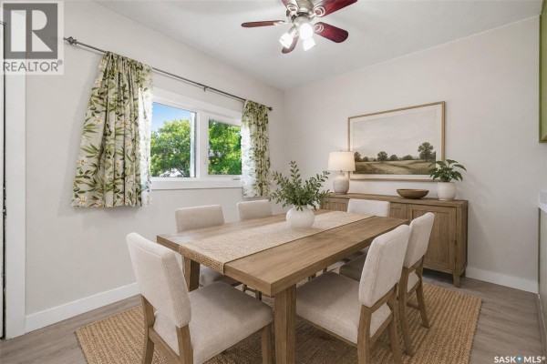 Dining room with a wood table, upholstered chairs, and decorative wall art. - 1919 14th Street W, Prince Albert
