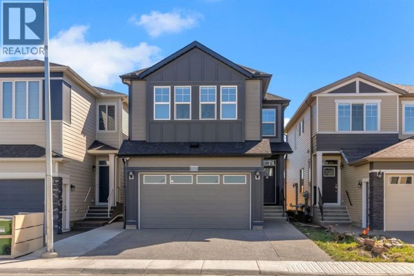 Front exterior of a modern two-story house with a dark gray and beige facade, under a daytime sky. - 192 Cornerbrook Road Ne, Calgary