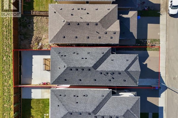 Top-down view of the property showing the house, driveway, backyard, and fence line. - 192 Cornerbrook Road Ne, Calgary