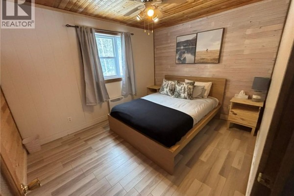 Cozy bedroom with wooden ceiling, double bed, and natural light from window. - 192 Rang 5 Et 6 Rd, Saint Quentin