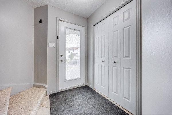 Interior entryway with grey walls, a white door, and a large white closet. - 192 Rue De Châteaufort, Gatineau