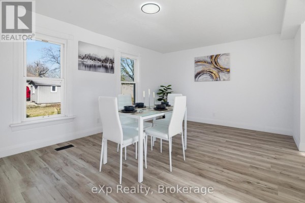 Dining room with white table and chairs, wood floors - 192 William Street W North Middlesex