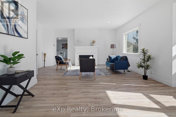 Living room with fireplace, blue sofa, and modern decor - 192 William Street W North Middlesex