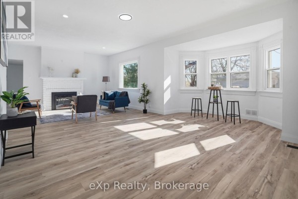 Living room with fireplace and bay windows - 192 William Street W North Middlesex