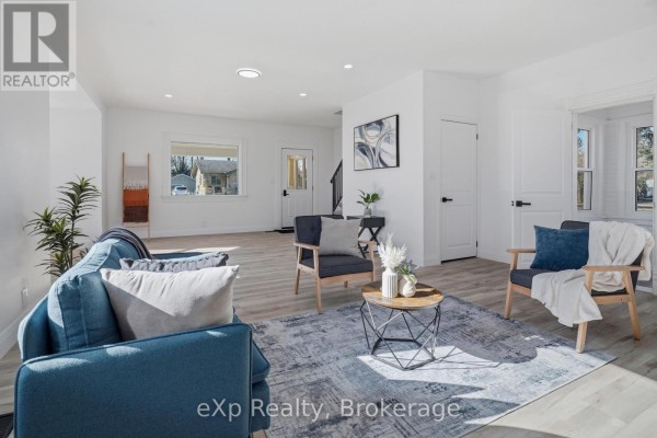 Living room with blue sofa, armchairs, and coffee table - 192 William Street W North Middlesex