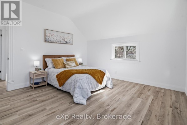 Bedroom with vaulted ceiling and mustard yellow accents - 192 William Street W North Middlesex