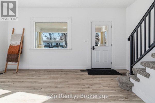 Exterior of a two-story yellow house with white trim and a metal roof. - 192 William Street W, North Middlesex