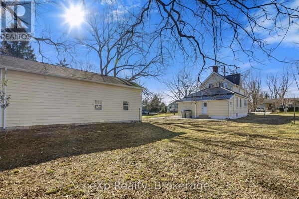 Yellow house with metal roof & detached garage - 192 William Street W North Middlesex