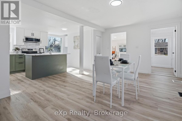 Modern kitchen with green island and dining area - 192 William Street W North Middlesex