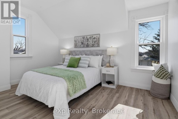 Bedroom with bed, nightstands, lamps, and windows - 192 William Street W North Middlesex