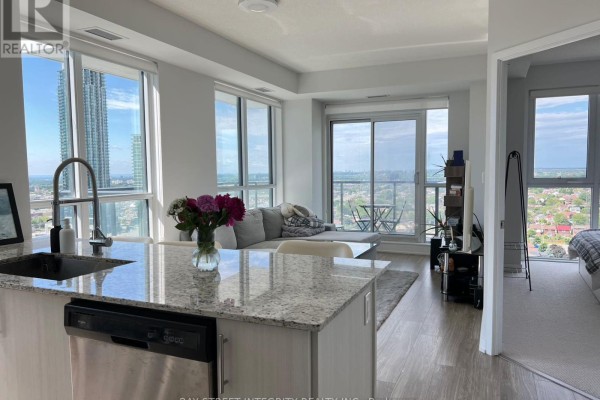 Living room with grey sectional sofa and large windows overlooking the city. - 1920 - 4055 Parkside Village Drive, Mississauga