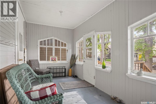 Front door and large windows of the brown house with wood siding. - 1921 Garnet Street, Regina
