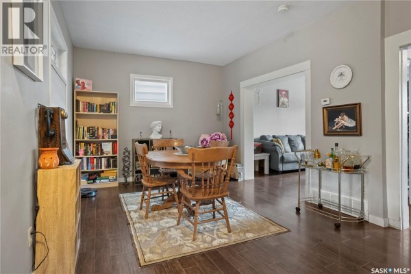 Interior porch with large windows, light gray paneled walls, and a green wicker chair. - 1921 Garnet Street, Regina