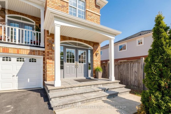 Close-up of the entrance to a brick house with double gray doors and stone steps. - 193 Queen Mary Drive, Brampton