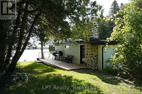 Aerial view of the property showing the house, lawn, docks, and waterfront access. - 193 Tamarac Road, Northern Bruce Peninsula