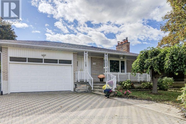 Exterior of a brick house with a white garage door, paved driveway, and front porch. - 193 The Westway, Toronto