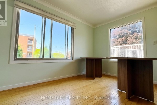 Office room with light green walls, hardwood floors, and two dark desks. - 1939 St. Joseph Boulevard, Ottawa