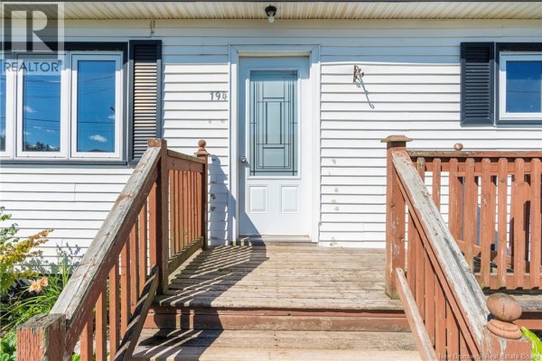 Close-up of the wooden front porch steps and white front door with glass. - 194 Jones Street, Moncton