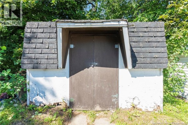 Exterior view of a small, detached storage shed with double wooden doors. - 194 Jones Street, Moncton