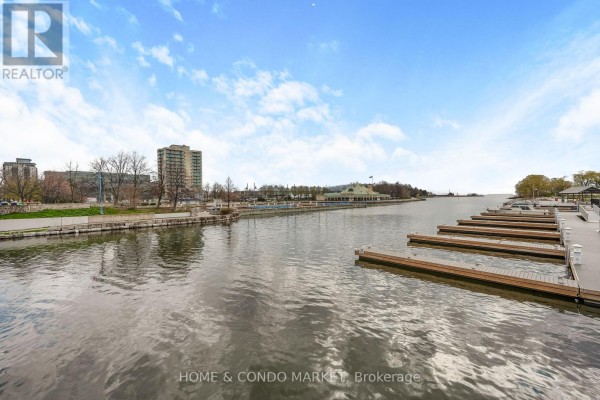Waterfront view with marina docks, buildings, and a cloudy blue sky. - 194 Lakeshore Road W, Mississauga