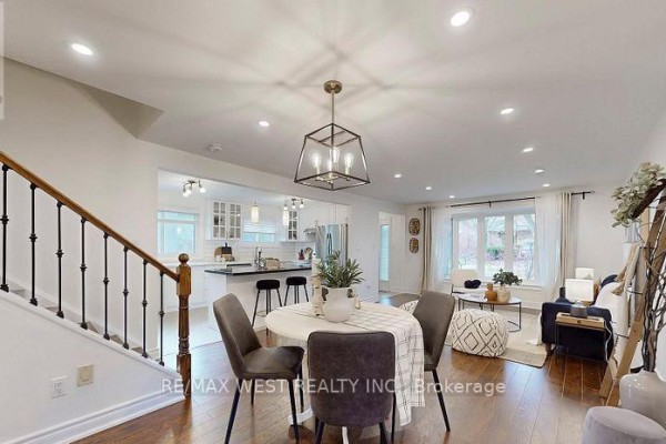 Dining area with a round table, modern lighting, and open layout to kitchen. - 194 Sewell Drive, Oakville