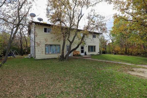 Side view of a duplex with a large tree in front. - 194 St Phillips Drive, Arborg