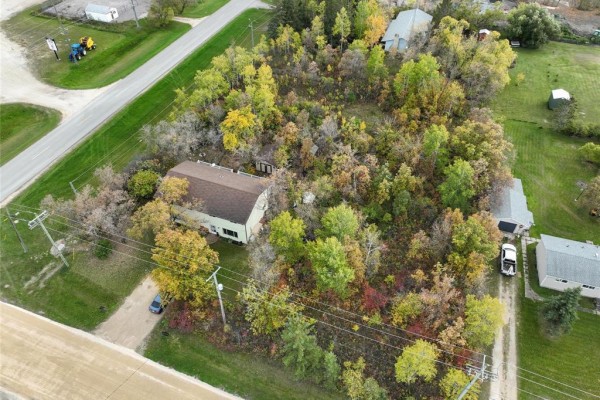 Aerial view of a duplex surrounded by trees in autumn. - 194 St Phillips Drive, Arborg