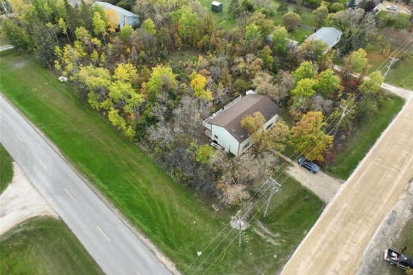 Overhead view of a duplex property with wooded surroundings and nearby roads. - 194 St Phillips Drive, Arborg