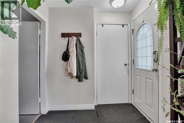 Interior entryway with a white door, coat rack, and dark grey floor mat. - 1940 Coy Avenue, Saskatoon
