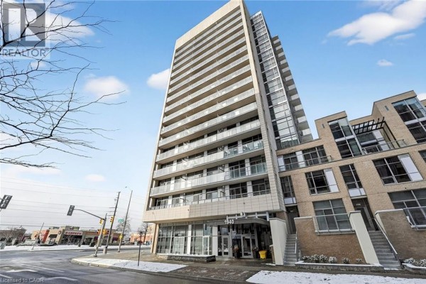 Low-angle exterior view of the apartment building showing multiple floors and balconies. - 1940 Ironstone Drive Unit# 1006, Burlington