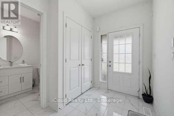 Interior entryway with white walls, tiled floors, double closet doors, and a glass-paneled front door. - 1944 Don White Court, Oshawa