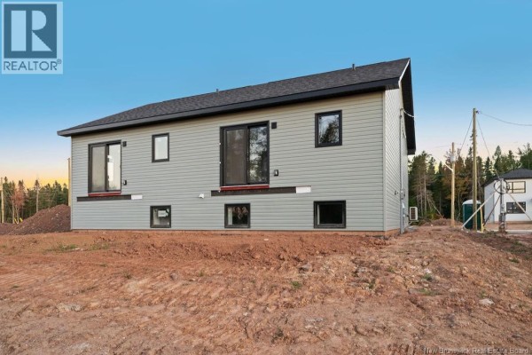 Side view of a duplex with grey siding, dark windows, and a sliding glass door. - 195 Carrington Drive, Riverview