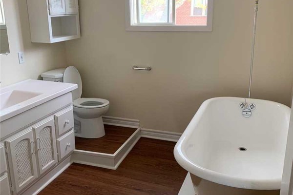 Bathroom with a white clawfoot tub, toilet, and vanity with white cabinetry. - 195 Division Street, Cobourg