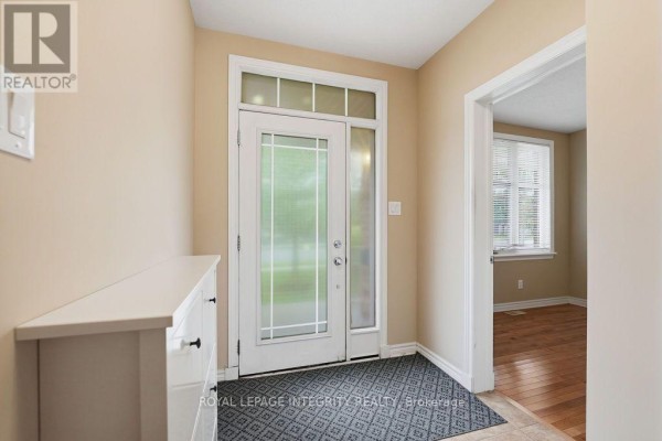 View of a kitchen with cream cabinets and dark countertops, open to the living room. - 195 Keyrock Drive, Ottawa