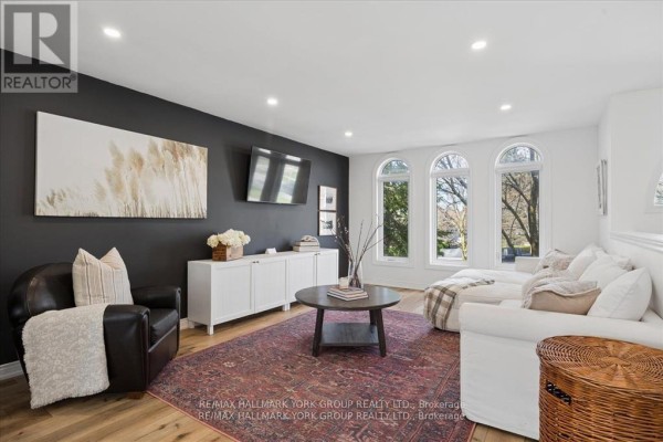 Interior view of the foyer looking into the living area with fireplace and white walls. - 195 King Street, East Gwillimbury