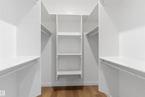 Spacious white walk-in closet with multiple shelves and hanging rods. - 19503 30 Ave Nw Nw, Edmonton