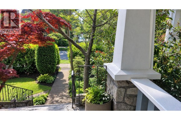 View down from stone steps of a green lawn and manicured hedges with a red Japanese maple tree. - 1951 Napier Street, Vancouver
