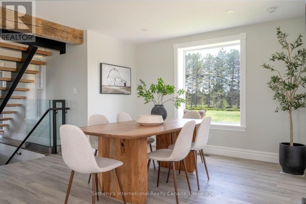 Wooden dining table and chairs with large window view, modern staircase - 1952 Nottawasaga N Clearview
