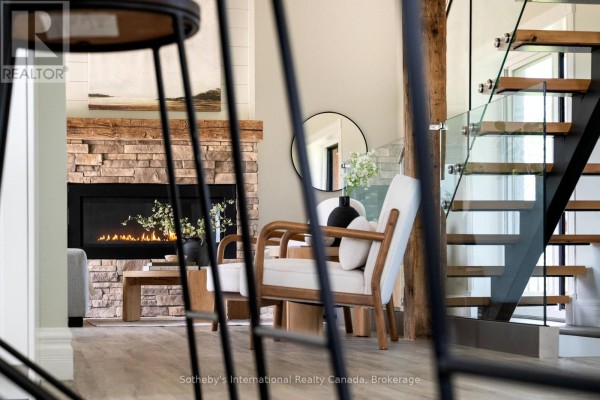Modern living room with stone fireplace and glass staircase - 1952 Nottawasaga N Clearview