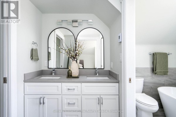 Double vanity with arched mirrors, soaking tub, and toilet - 1952 Nottawasaga N Clearview