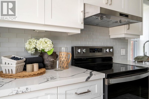 Modern kitchen with white cabinets, quartz counters, grey subway tile backsplash, and stainless steel appliances - 1952 Nottawasaga N Clearview