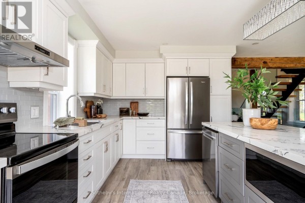 Modern kitchen with island, marble countertops, subway tile, stainless steel appliances - 1952 Nottawasaga N Clearview