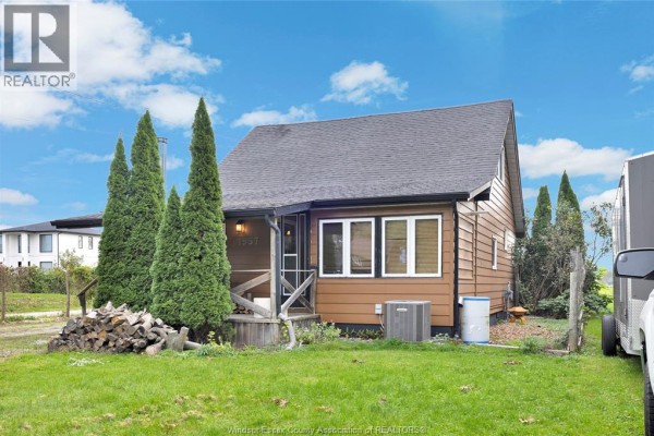 View of the house exterior from the left side, showing the entrance and lawn. - 1957 Front Road North, Amherstburg